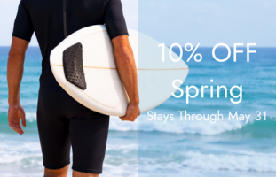 Surfer in a spring wetsuit walking toward the ocean with text reading 10% Off Spring arrivals in March, April, and May.