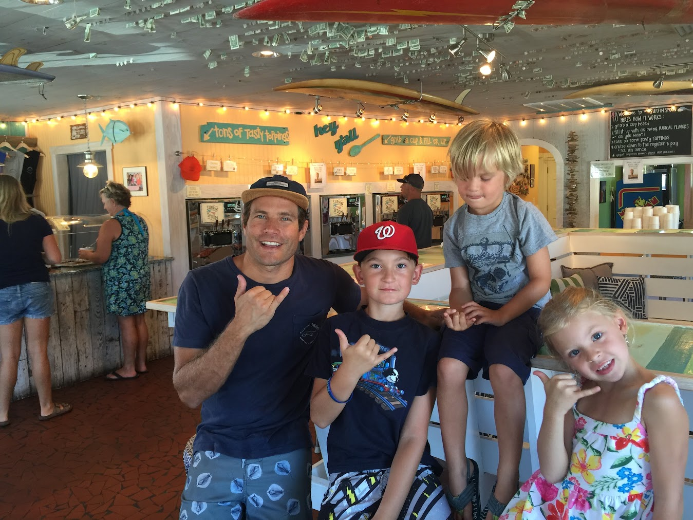 Surfin’ Spoon owner Jesse Hines with a family visiting the Nags Head frozen yogurt shop