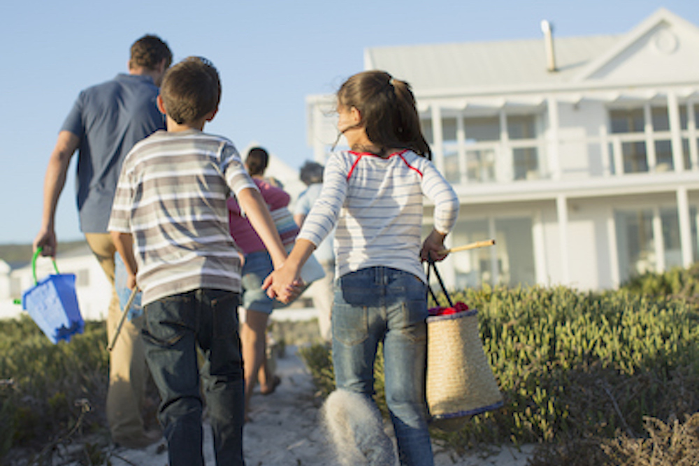 family walking toward beach house 