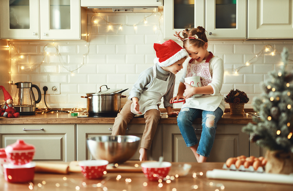 kids in a kitchen that's decorated for Christmas