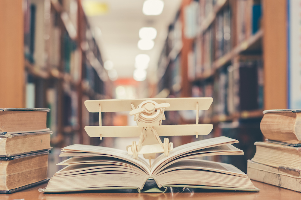 model airplane on an open book in a library