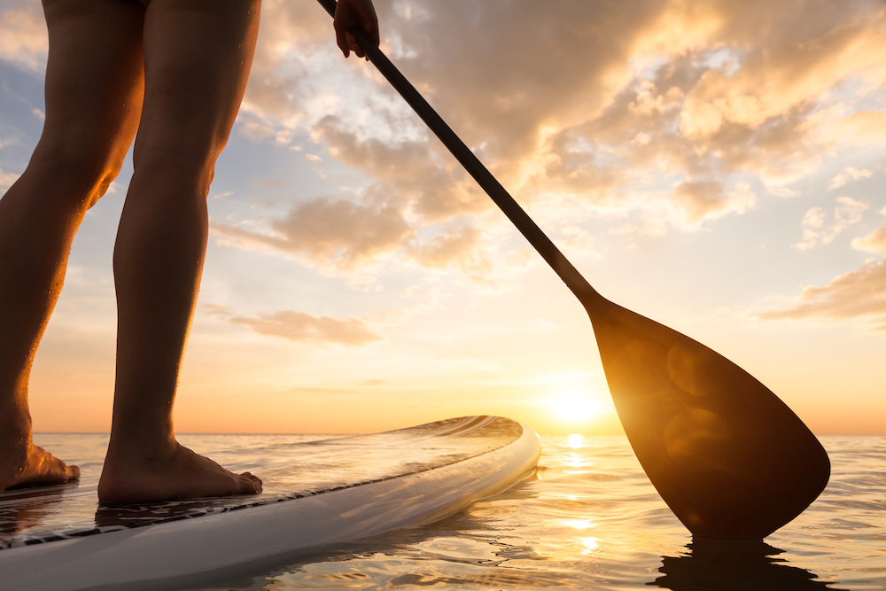 focus on woman's legs on a stand up paddleboard